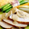 Kalkoenfilet met champignonsaus op wit bord